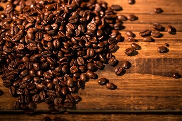 Flat illustration is showing heap of roasted coffee beans shining on wooden surface with wood grain