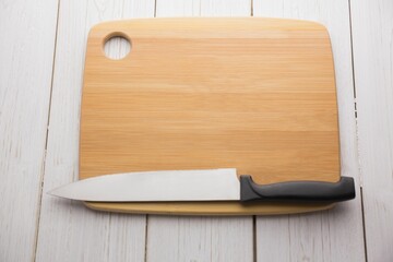 Knife and chopping board on hardwood floor