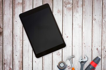 Tools and tablet on wooden background