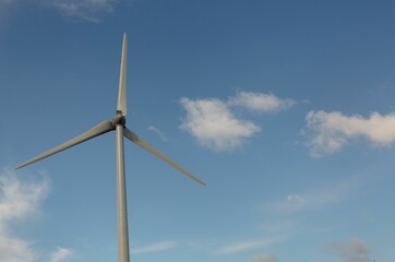 Windmill spinning against blue sky