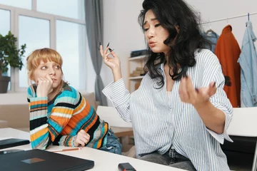  young adult woman and colleague socializing at workplace, business discussion, Gen Z coworkers collaborating and working in casual office environment © SHOTPRIME STUDIO