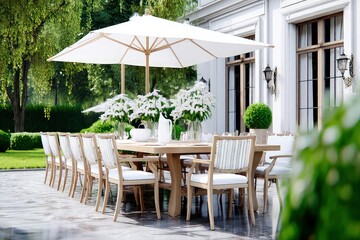 Luxury outdoor dining setup with wooden table, white umbrella, floral centerpiece, and garden view for serene alfresco entertaining experience