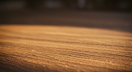 Golden sunlight illuminates a rustic wooden surface, highlighting its textured grain. An empty, warm background for product placement or presentation.