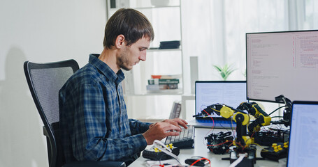 Young adult male freelance developer typing write prompt AI bot app program nomad terminal with...