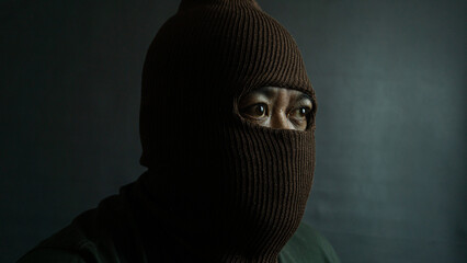 Male subject with brown fabric eye mask fully worn on face, isolated on black, suggesting secrecy,...