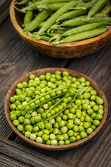 Fresh green peas in wooden bowls