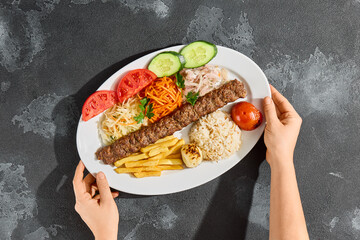 Lamb kebab platter, bright overhead style, rustic stone surface for Turkish grill menu