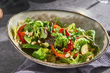 Green salad with peppers and zucchini, bright mood, angled composition, rustic ceramic bowl