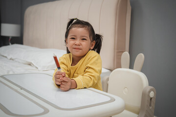 happy toddler girl holding syrup medicine with syringe