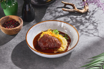 Braised beef cheek with mashed potatoes, bright overhead, contemporary restaurant plating