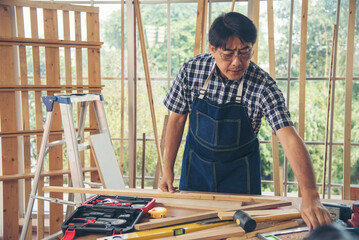 DIY craftsperson asian man working wood heap carpenter objects woodwork desk. Architect man hands...