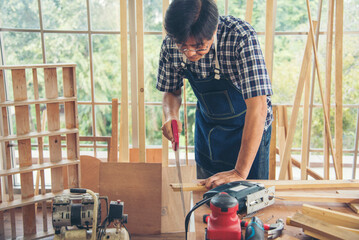 DIY craftsperson asian man working wood heap carpenter objects woodwork desk. Architect man hands...