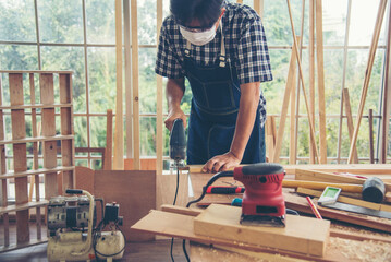DIY craftsperson asian man working wood heap carpenter objects woodwork desk. Architect man hands...