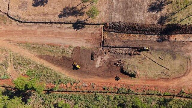 High-altitude view captures synchronized machinery reshaping terrain under sunlight. Ideal for construction reels or equipment demos.