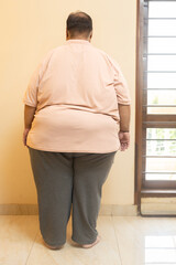 Overweight plus size indian man standing. Back view of fat guy. Obesity and weight loss.concept.