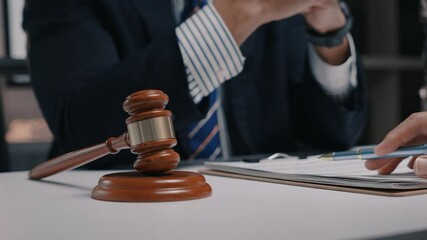 Professional lawyer guiding client through contract signing, wooden gavel resting on office desk, emphasizing legal consultation and agreement details