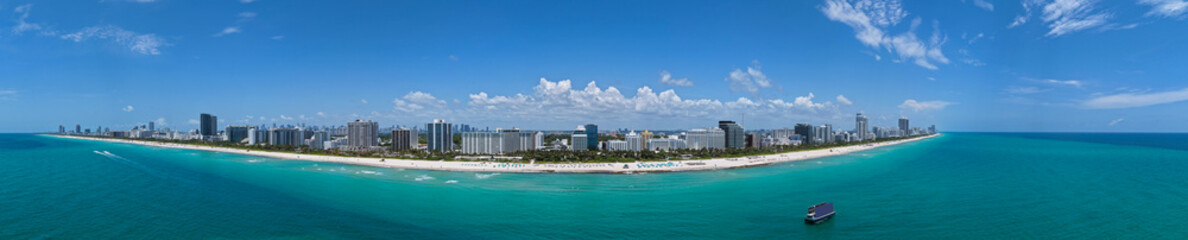 Naklejka premium Aerial view of South Beach coastline. Miami skyline with tropical blue waters panorama. Panorama over the Miami skyscrapers. Miami, Florida waterfront cityscape. Iconic South Florida travel