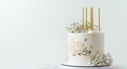 Beautiful white birthday cake decorated with golden candles and field  gypsophila flowers on the white background
