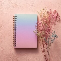 Colorful spiral notebook and dry flowers on pink background in soft pastel style with clean light and texture