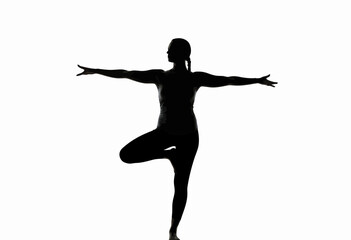 Woman practicing yoga in tree pose with arms extended  