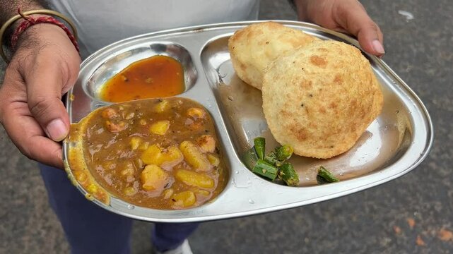 Kachori sabji served with spicy potato curry and chutney