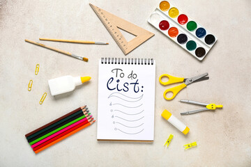 Composition with open blank notebook and stationery supplies on white grunge background, closeup