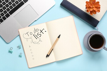 Notebook with blank to-do list, laptop, coffee and stationery on light blue background
