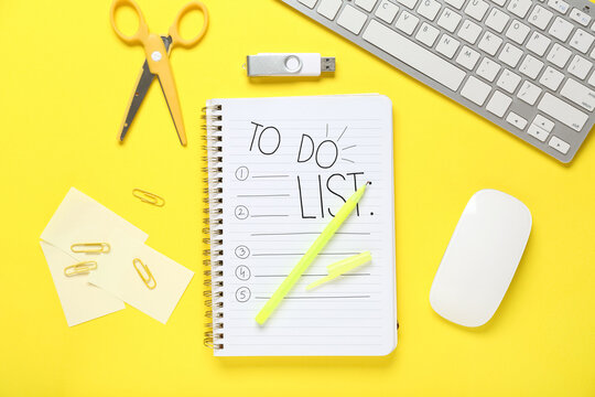 Notebook with blank to-do list, PC keyboard and stationery on yellow background