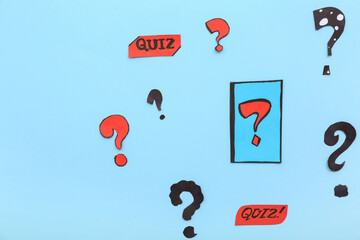 Paper quiz cards with question marks on blue background