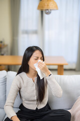 Woman suffering from runny nose at home