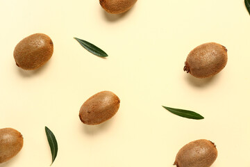 Many fresh kiwi and leaves on yellow background
