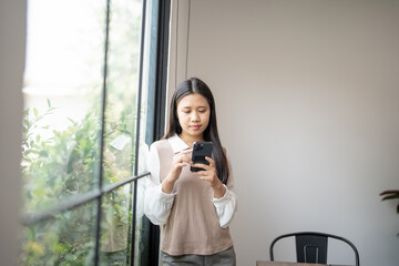 Young woman user customer hold smart phone Social media addiction with finger rings using online...