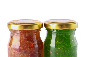Jars with tasty gooseberry jam on white background
