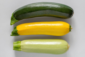 Multicolored zucchini on a gray background. Three different zucchini.