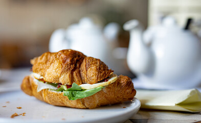 tasty croissant with salad goat cheese on a white plate, breakfast with croissant