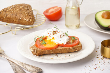 Plate of tasty sandwich with egg on grey background