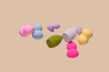 Flying different makeup sponges on beige background