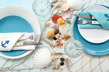 Beautiful table setting with marine decor on blue background