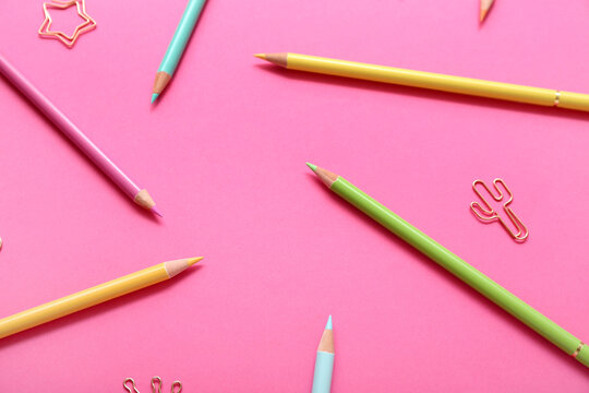 Pencils with paper clips on pink background