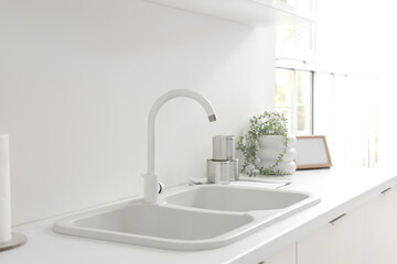 White counter with sink in interior of modern kitchen, closeup