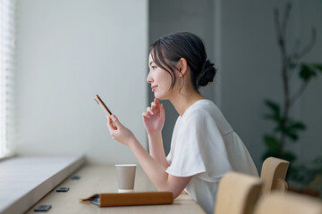 カフェでスマホを使う女性