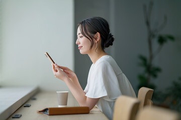カフェでスマホを使う女性