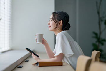 カフェでスマホを使う女性