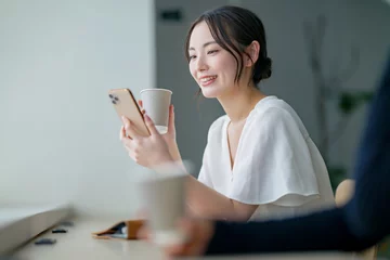  カフェでスマホを使う女性 © naka