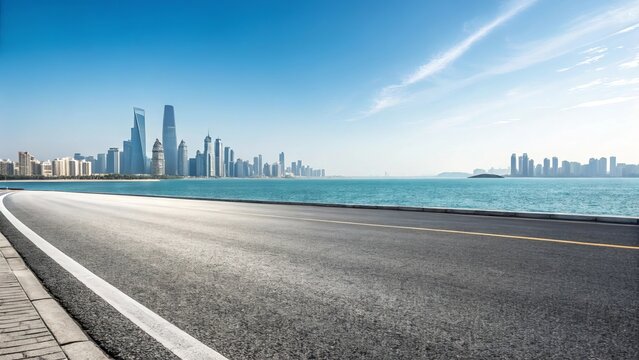 Modern city skyline across the turquoise ocean with a scenic coastal road in the foreground