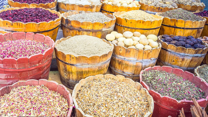 Colorful different spices and herbs in baskets in the spice mark