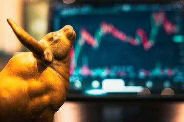Golden bull in front of tablet opening rising stock market. Concept of bullish stock market with bull as symbol.