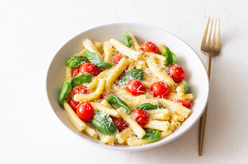 Pasta casarecce with tomatoes, basil and cheese. Italian cuisine. Vegetarian food.