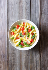 Pasta casarecce with tomatoes, basil and cheese. Italian cuisine. Vegetarian food.