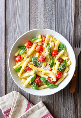Pasta casarecce with tomatoes, basil and cheese. Italian cuisine. Vegetarian food.